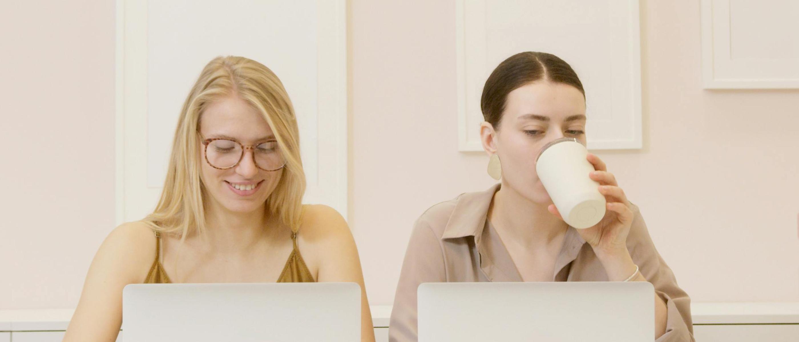 Twee jonge vrouwen aan het werk achter laptop