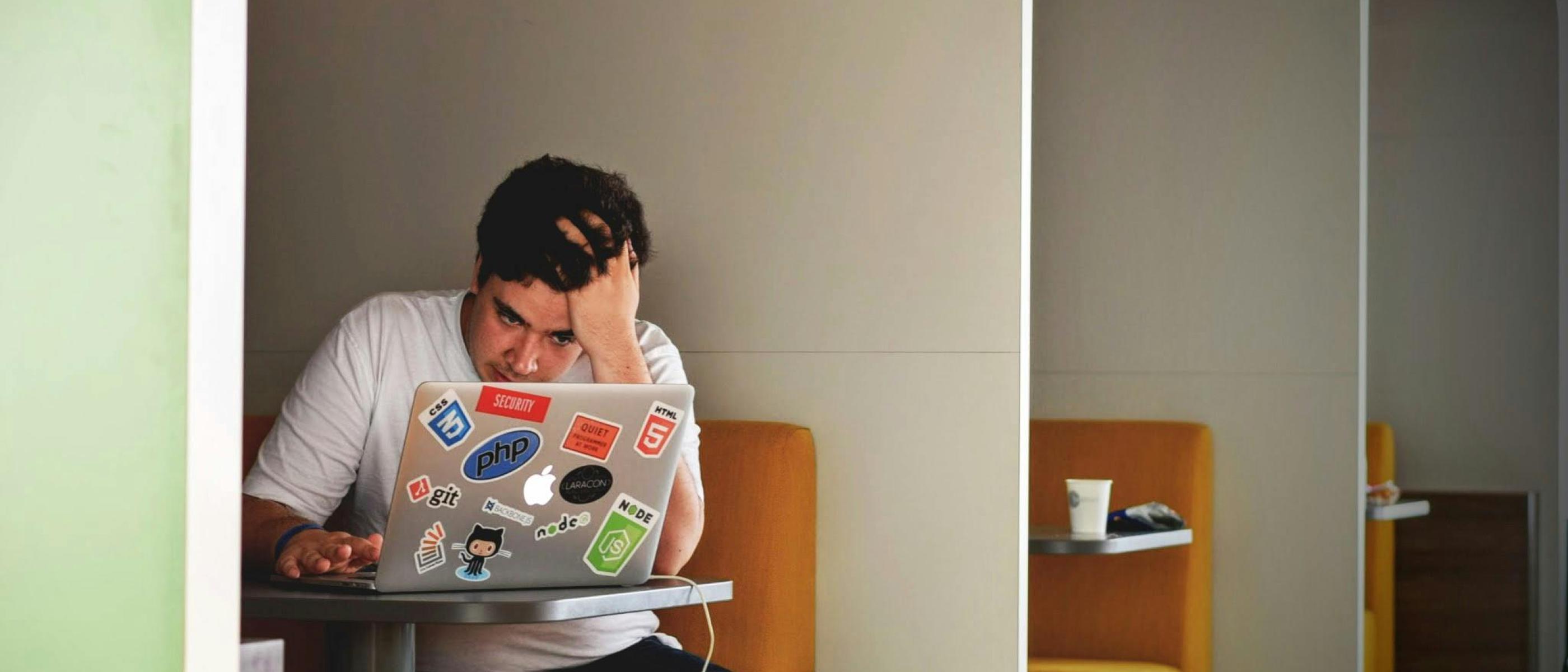 jongere zit voor scherm van laptop en maakt zich duidelijk zorgen