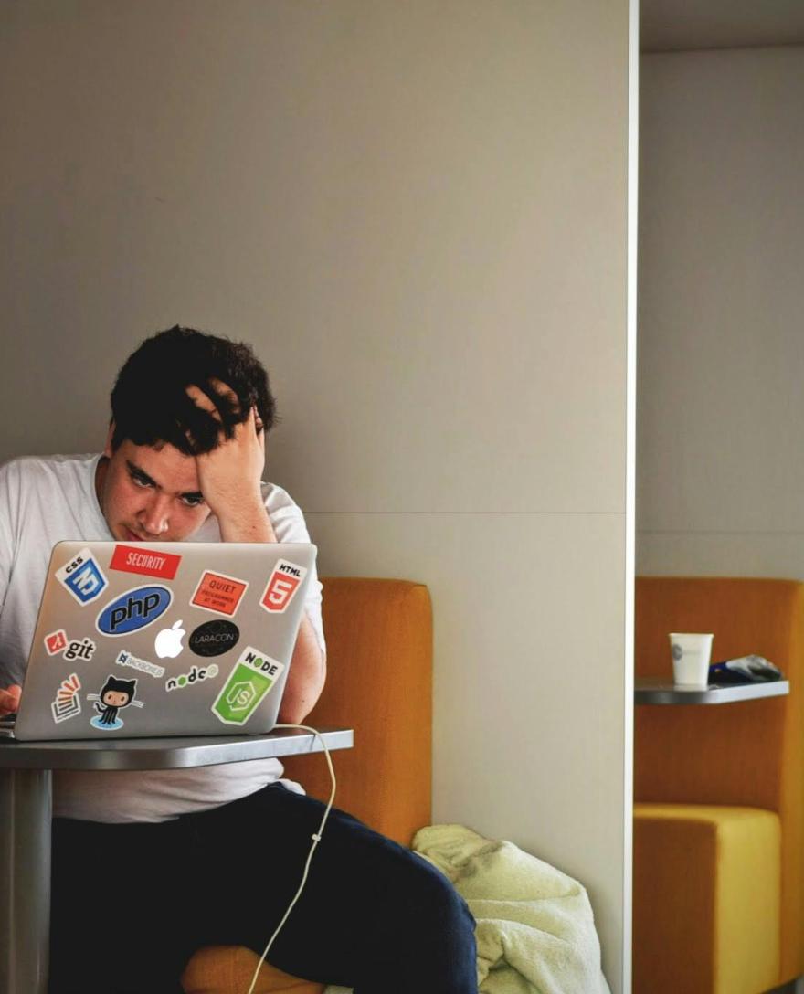 jongere zit voor scherm van laptop en maakt zich duidelijk zorgen